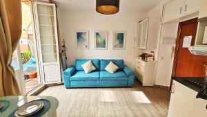 uma sala de estar com um sofá azul numa cozinha em Sol de Málaga em Málaga