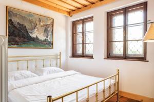a bedroom with two beds and two windows at Spacious And Historic Villa With Bled Castle View in Bled