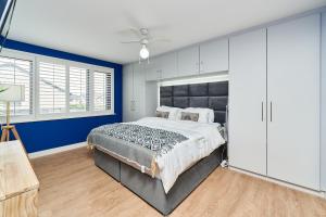 sypialnia z dużym łóżkiem i niebieskimi ścianami w obiekcie Modern Clonsilla Townhouse Sleeps 6 w Dublinie