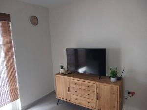 a flat screen tv sitting on top of a wooden dresser at Blue Lagun Apartment B in Willemstad