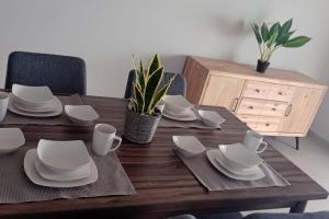 a wooden table with white plates and napkins on it at Blue Lagun Apartment B in Willemstad