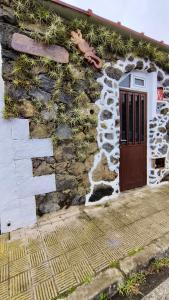 een huis met een stenen muur met een deur bij Cuevita Bimbache in Valverde