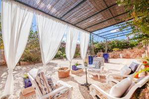 a patio with white chairs and a table at Finca Son Marimon in Santanyi