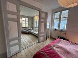 a bedroom with a door leading to a living room at Bylejlighed i det gamle Svendborg in Svendborg