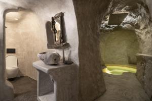 a bathroom with a sink and a tub in a cave at Capetan Nikolas-boat house in Klima +21 photos