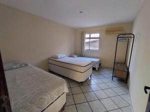 a small bedroom with two beds and a mirror at APtº 1º andar em Olinda Casa Caiada a 100 mts da praia in Olinda