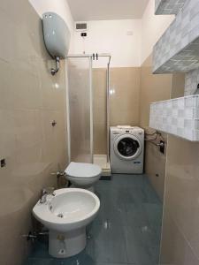 a bathroom with a toilet and a washing machine at Casa vacanze Omero in San Salvo +24 photos
