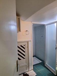 a bathroom with a shower and a toilet and a door at Jardin de Fann in Dakar