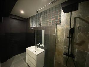 un bagno con doccia e lavandino bianco di Passion a Schœlcher
