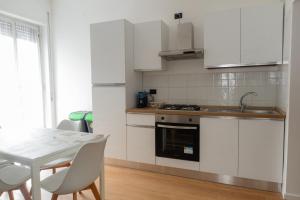a kitchen with white cabinets and a table with chairs at Casa vacanze Omero in San Salvo
