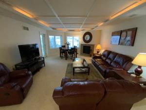 un soggiorno con divani in pelle marrone e TV di Spacious furnished suite at Peninsula Bay Resort a Traverse City