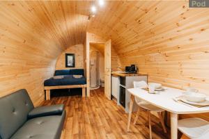 una habitación con una cama y una mesa en una cabaña en Firbush Lochside Lodges en Killin