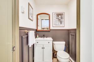 a bathroom with a toilet and a sink and a mirror at Pet-Friendly Hopewell Junction Home with Pool in Hopewell Junction +23 photos