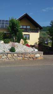 a house with a stone retaining wall in front of a house at Wohnung mit Blick auf die Weinberge in Kröv