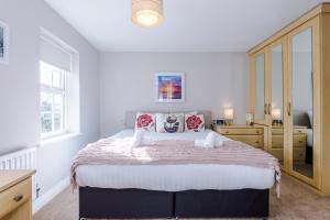 a bedroom with a large bed and a dresser at Cravenwood Townhouse with games room - Sleeps 5 in Manchester