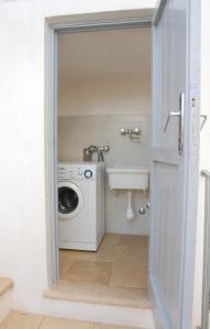 ein Badezimmer mit Waschmaschine und Waschbecken in der Unterkunft Casa Mario in Cisternino
