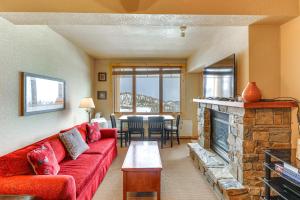 sala de estar con sofá rojo y chimenea en Whitefish Mountain Condo - Ski Resort On-Site! en Whitefish
