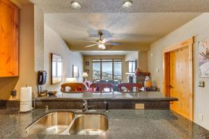 a kitchen with a sink and a living room at Whitefish Mountain Condo - Ski Resort On-Site! in Whitefish