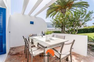 Un comedor con mesa y sillas y una palmera. en #220 Windmill Hill by Home Holidays, en Albufeira