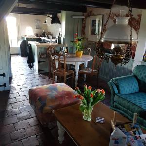 a living room with a table and a kitchen at Âlde Bakhûs in Sondel