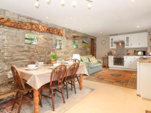 a kitchen and dining room with a table and chairs at Roofstones Cottage in Hawes