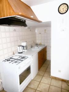 a white kitchen with a stove and a sink at Maison pittoresque à Mostuéjouls avec vue sur la montagne in Mostuéjouls