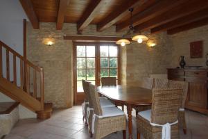 ein Esszimmer mit einem Holztisch und Stühlen in der Unterkunft Grand gite de la Bourrélie in Plazac