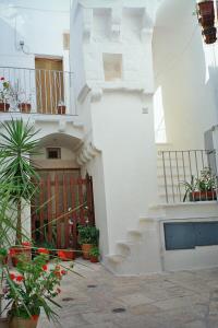 a white building with stairs and potted plants at Casa Mario in Cisternino