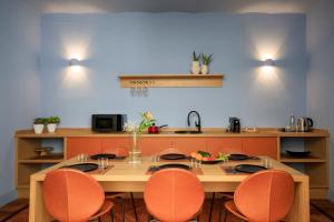 eine Küche mit einem Holztisch und orangefarbenen Stühlen in der Unterkunft Maison Belmonte - Suites in Palermo in Palermo
