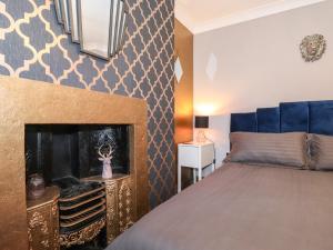 a bedroom with a bed and a fireplace at Flosh Cottage in Cleator