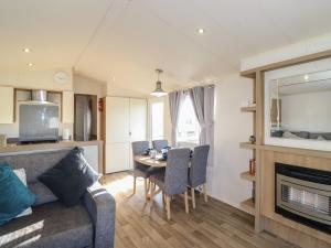 a living room with a couch and a table with chairs at Flosh Caravan in Maryport