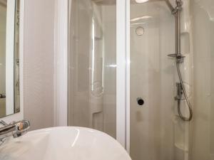 a bathroom with a shower and a white sink at Flosh Caravan in Maryport