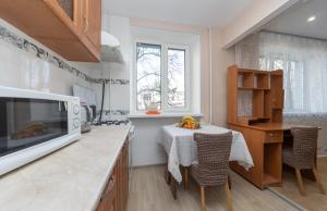 a kitchen with a table and a microwave at Уютная современная,однокомнатная квартира по Проспекту Леся Курбаса 9Д in Kyiv