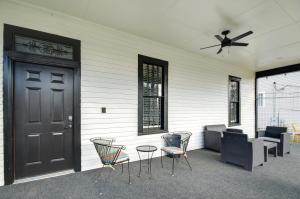 une terrasse couverte avec une porte noire, des chaises et une table dans l'établissement Stylish Home about 2 Mi to Jackson State and Belhaven!, à Jackson