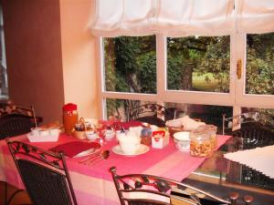 a dining room table with a pink table cloth and a window at Il Glicine in Zimone +25 photos
