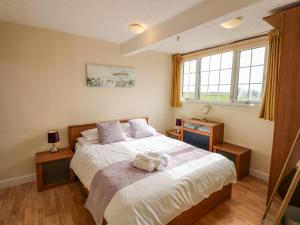 a bedroom with a bed with a teddy bear on it at Martell Cottage in Skegness