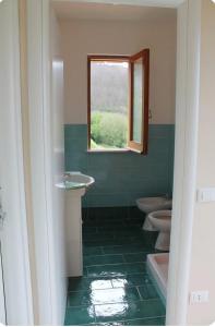 bagno con due servizi igienici e finestra di La Casa sulla Penisola Sorrentina a Vico Equense
