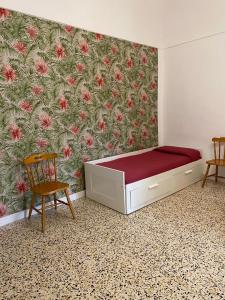 una camera con letto e parete con fiori di La Casa sulla Penisola Sorrentina a Vico Equense
