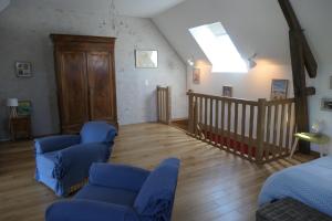 sala de estar con sillas azules y escalera en A la croisée des châteaux 3 étoiles, en Ouchamps