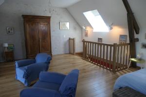 a living room with blue chairs and a staircase at A la croisée des châteaux 3 étoiles in Ouchamps