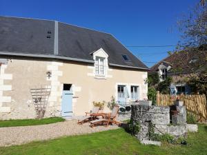 a house with a table and chairs in the yard at A la croisée des châteaux 3 étoiles in Ouchamps