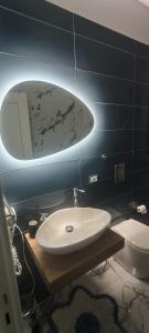 La salle de bains est pourvue d'un lavabo, d'un miroir et de toilettes. dans l'établissement B&B Crocco D'Oro, à Caltavuturo