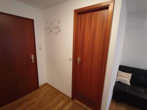 Camera con porta in legno e letto di Room in Guest room - Pension Forelle - Suite a Forbach