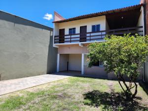 een huis met een balkon en een tuin bij Pousada Nossa Casa Barreirinhas in Barreirinhas