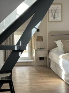 a bedroom with a bed and a desk and a window at Hôtel De La Marine in Arromanches-les-Bains