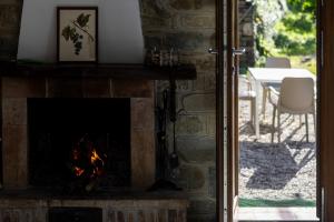 einen Kamin im Wohnzimmer neben einer Terrasse in der Unterkunft Bellezza In Cilento Panoramic Apts in Castellabate