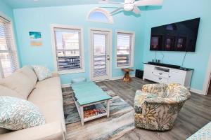 a living room with a couch and a tv at NH300, Driftwood Dreams- Oceanside, Near shopping, Close to Ocean! in Nags Head