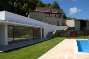 a villa with a swimming pool and a house at Gerês - Aldeia Turística de Louredo in Vieira do Minho
