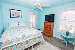 a blue bedroom with a bed and a television at NH300, Driftwood Dreams- Oceanside, Near shopping, Close to Ocean! in Nags Head