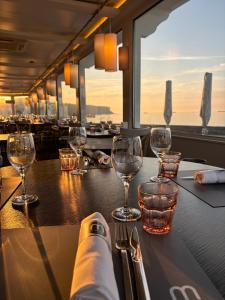 a table in a restaurant with wine glasses on it at Hôtel De La Marine in Arromanches-les-Bains